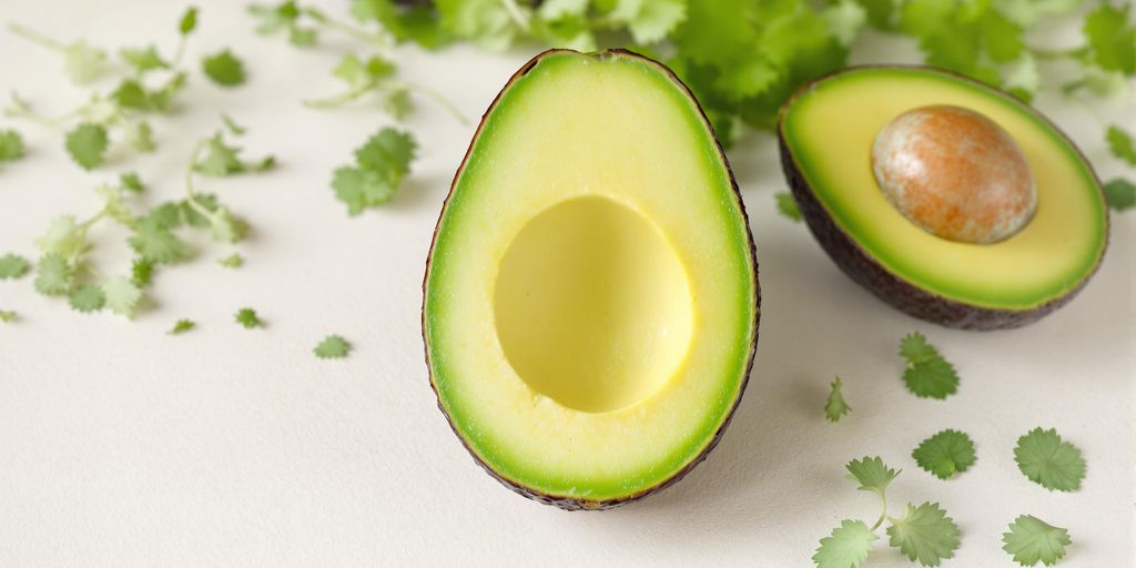 Descubra os 10 alimentos para baixar colesterol e melhorar sua saúde cardiovascular 2 Imagem de um abacate cortado ao meio.