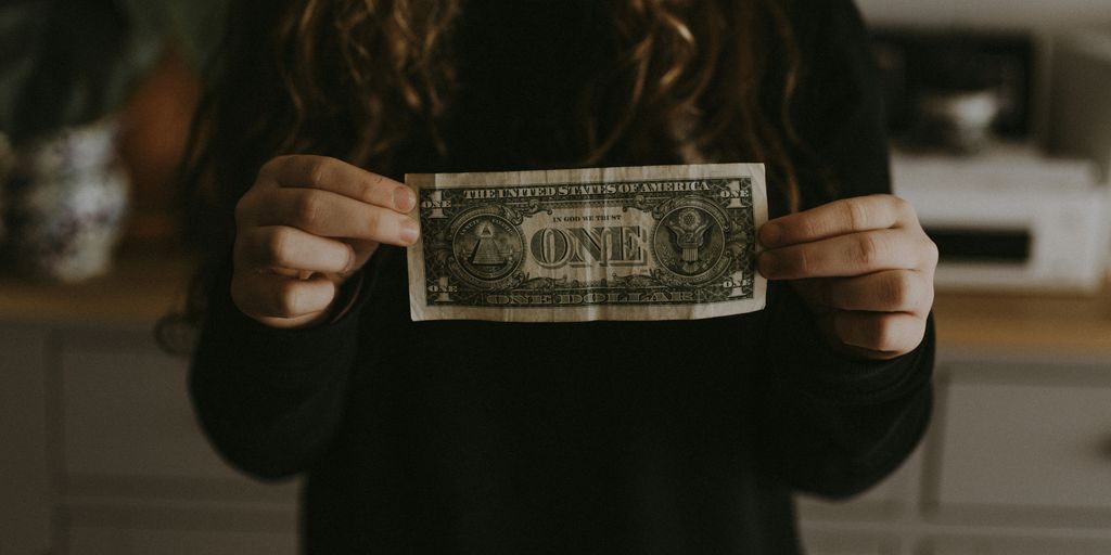 girl holding 1 U.S. dollar banknote