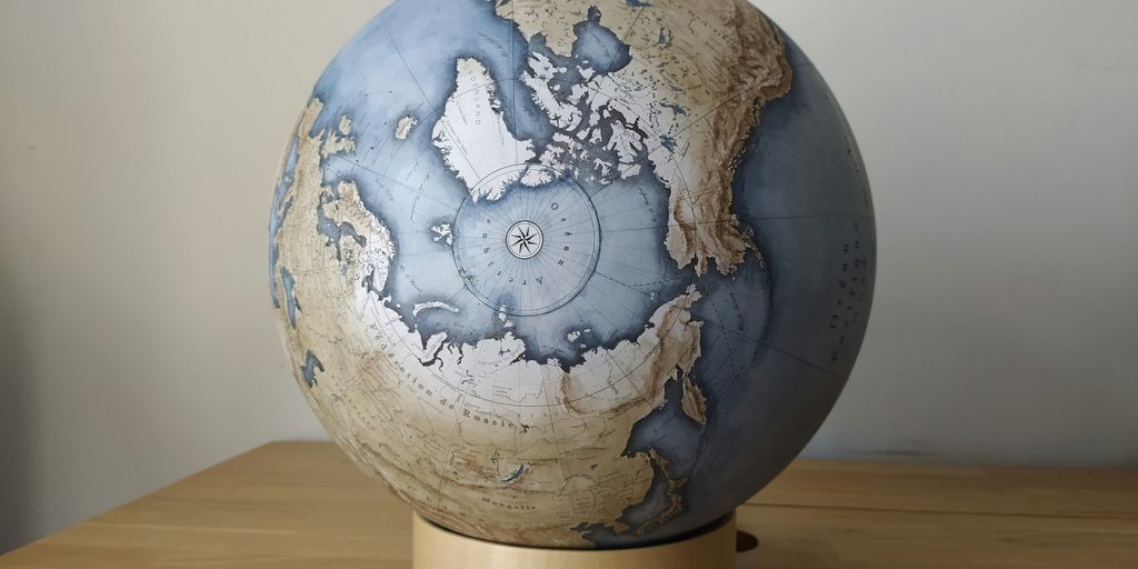 blue and white globe on brown wooden table