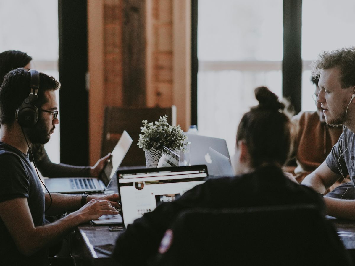 selective focus photography of people sits in front of table inside room