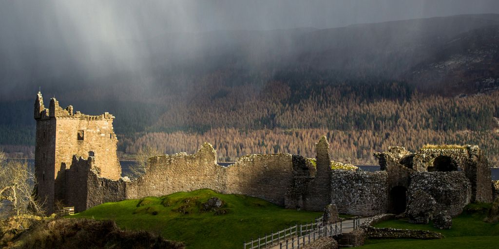brown castle near green field and brown trees