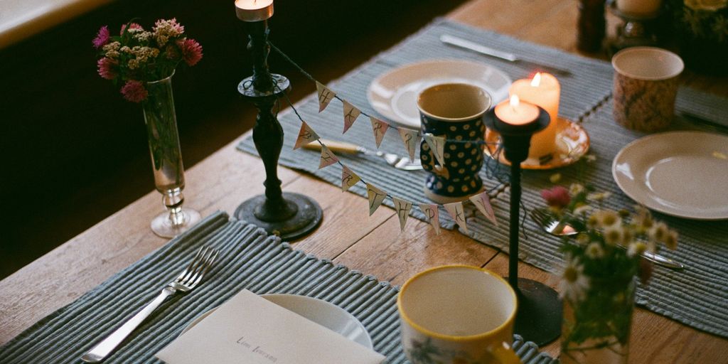 a table set for a meal with candles and plates