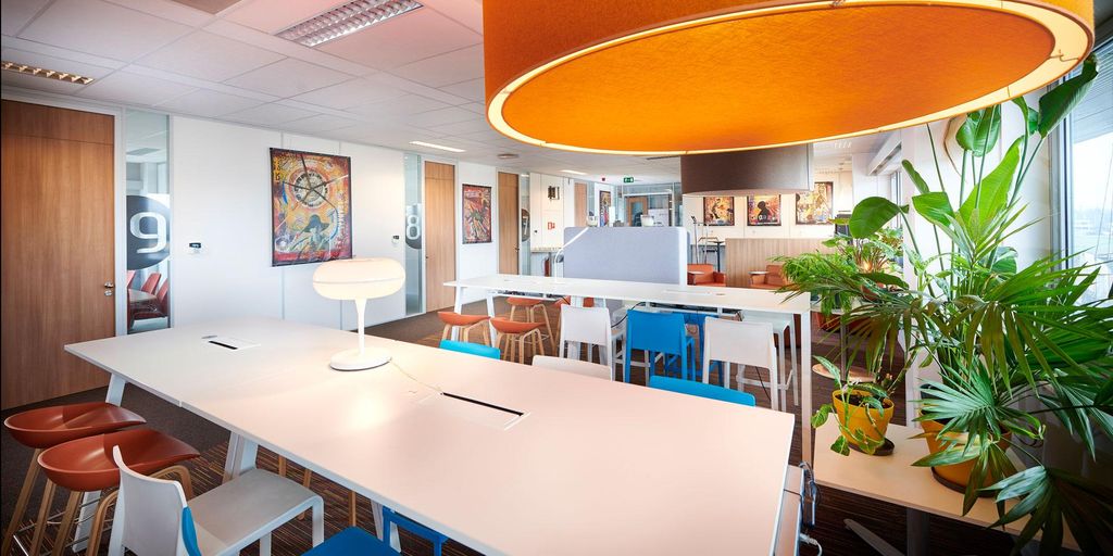 Bright office space with colorful furniture and large lamps.