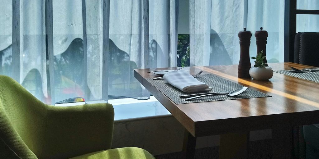 white sheer window curtain near brown wooden table
