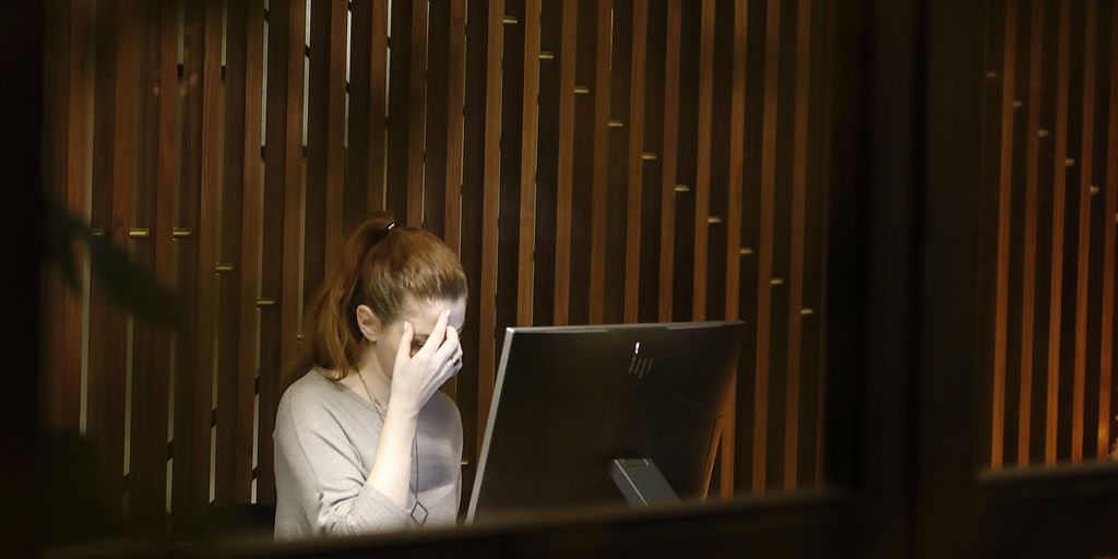 a woman sitting in front of a laptop computer