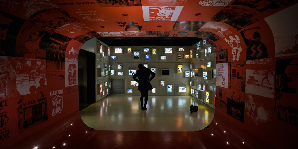 silhouette of woman standing inside room full of monitors