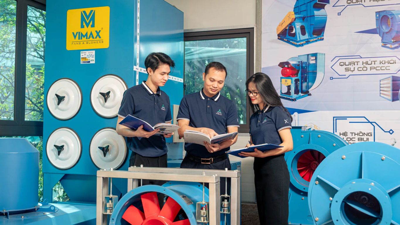 Three professionals discussing equipment in a technical setting.