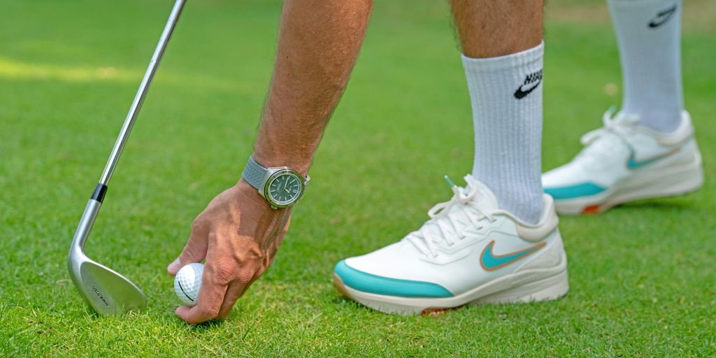 a man putting a golf ball on a tee