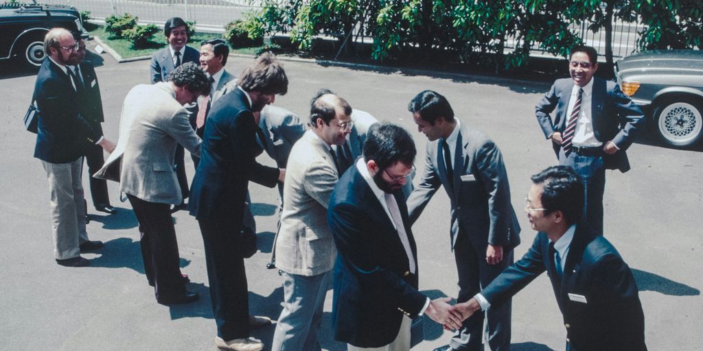 A group of men standing around each other in a parking lot