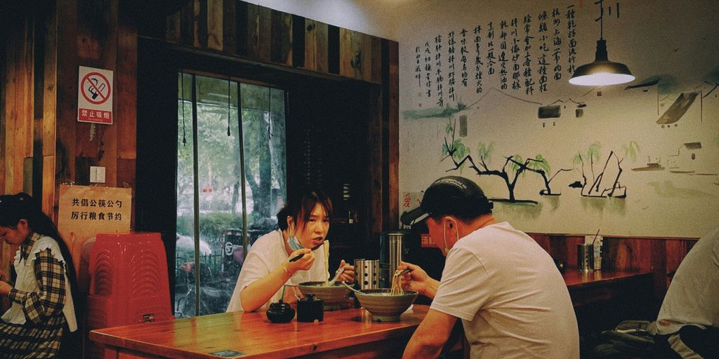 a group of people sitting around a wooden table