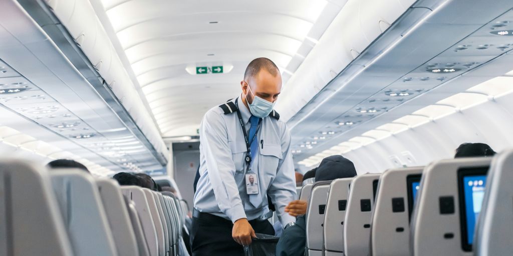 man in blue dress shirt standing in airplane