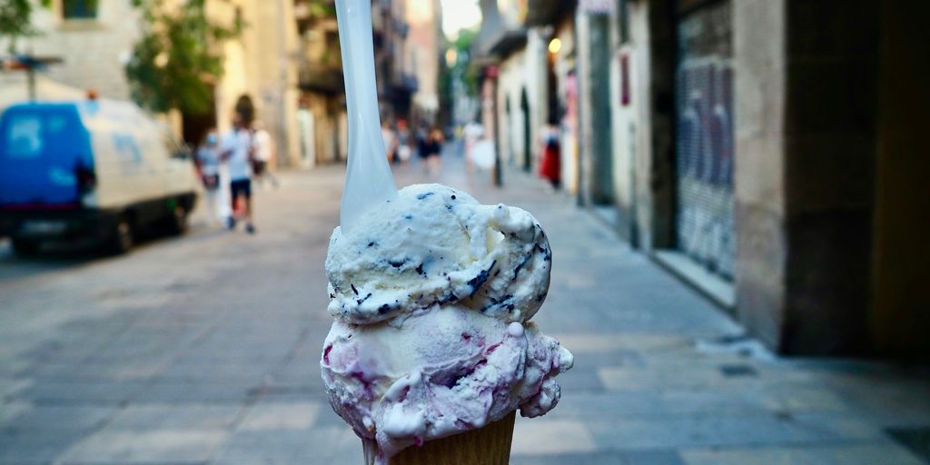 a scoop of ice cream sitting on top of a sidewalk
