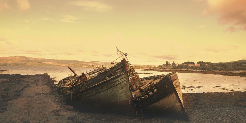 brown wreck boat near seashore during daytime