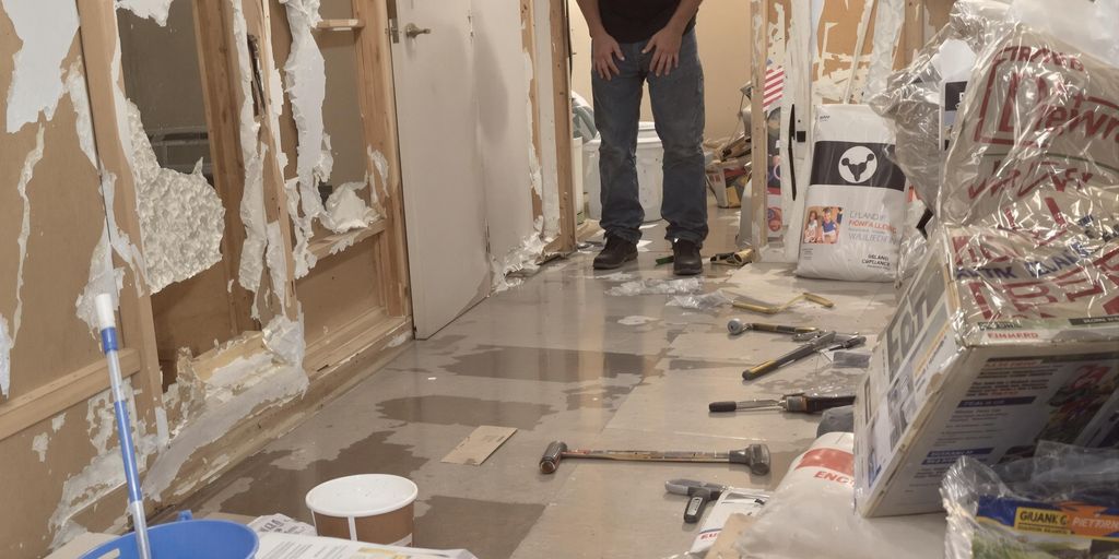 Inspecting water-damaged walls and floors for repairs.