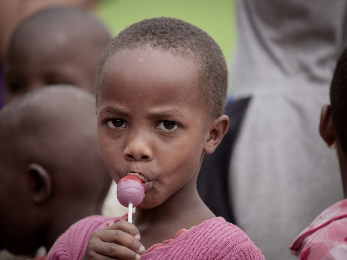 a young child is chewing on a lollipop