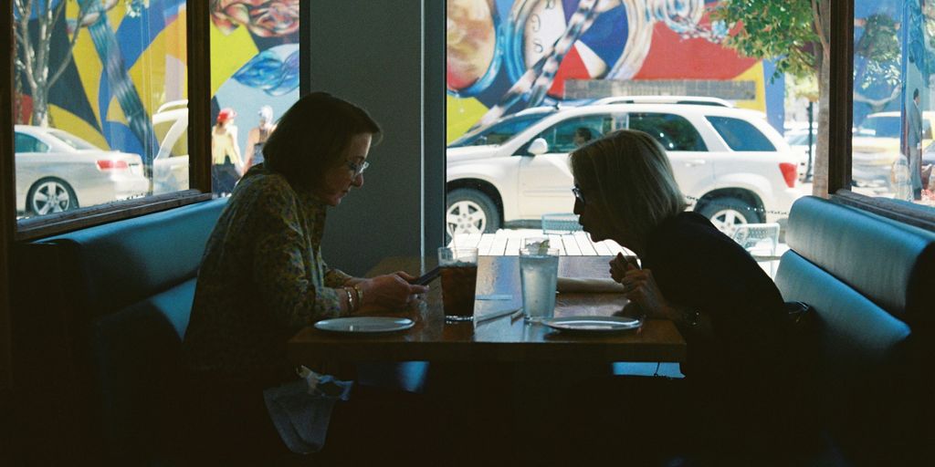 a man and a woman sitting at a desk in front of a window