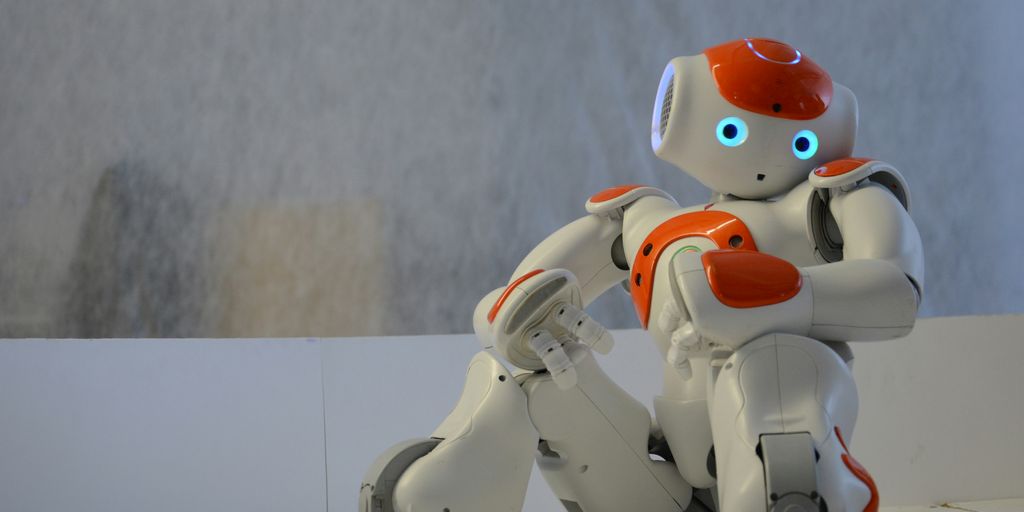 white and orange robot near wall
