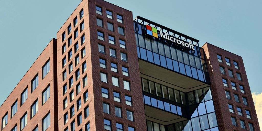 a tall brick building with windows and a sky background