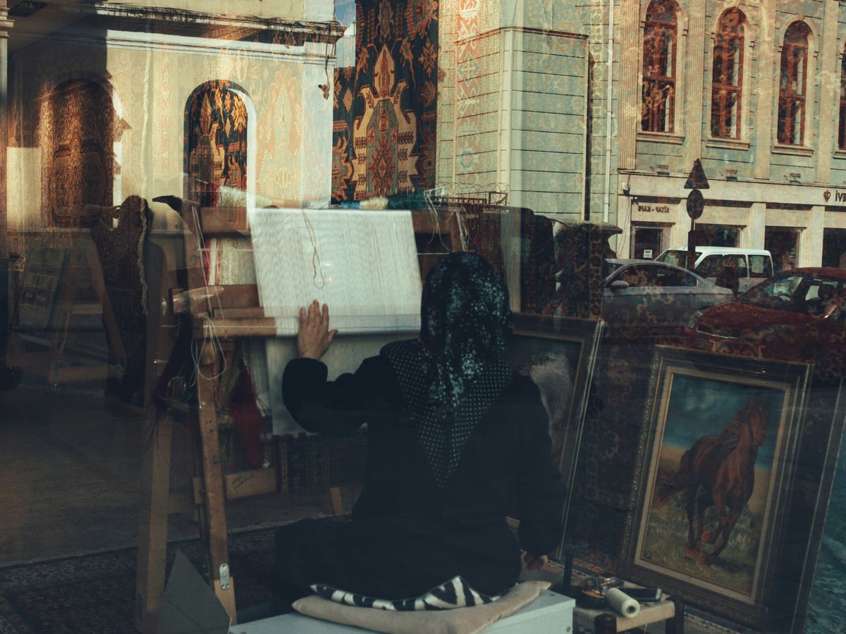 a woman sitting on a chair in front of a painting