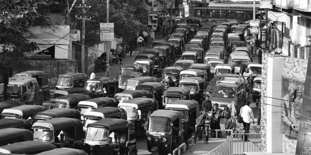 a black and white photo of a street filled with cars