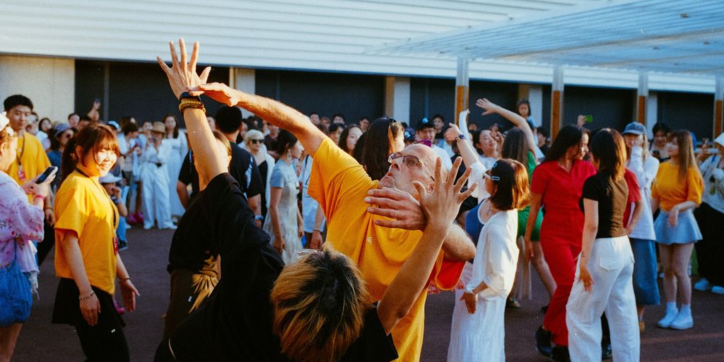 People dance enthusiastically in an outdoor space.