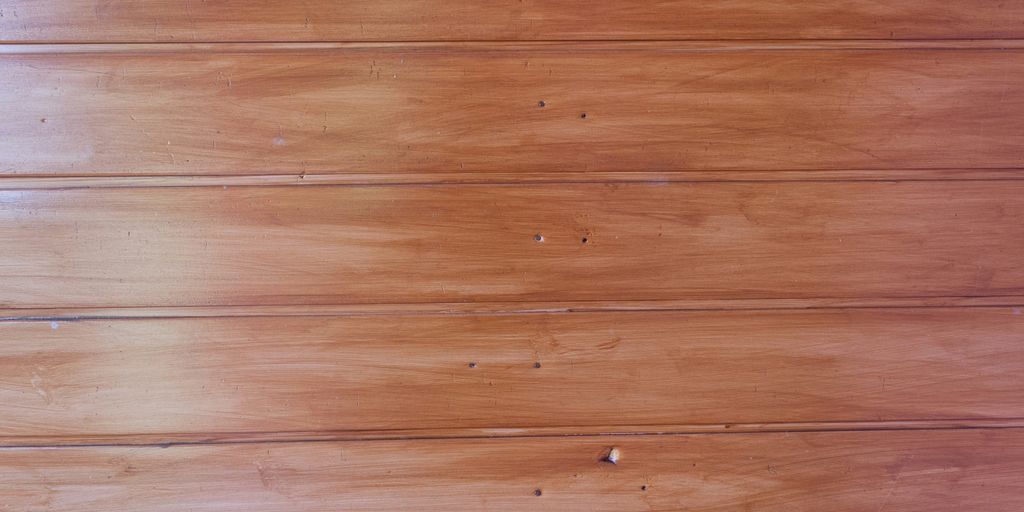 a cat laying on a wooden floor next to a wall