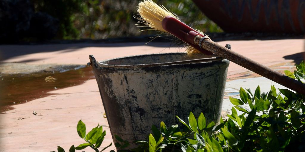 a brush sits in a bucket on the ground
