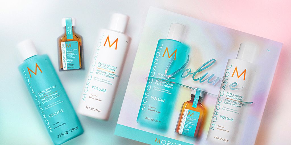 Haircare products from Moroccanoil displayed against a gradient background.
