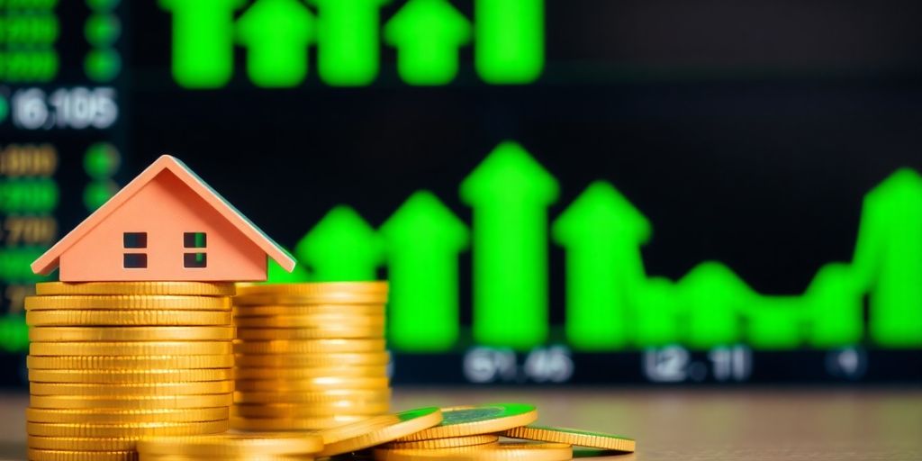 Stack of coins, miniature house, and stock ticker.