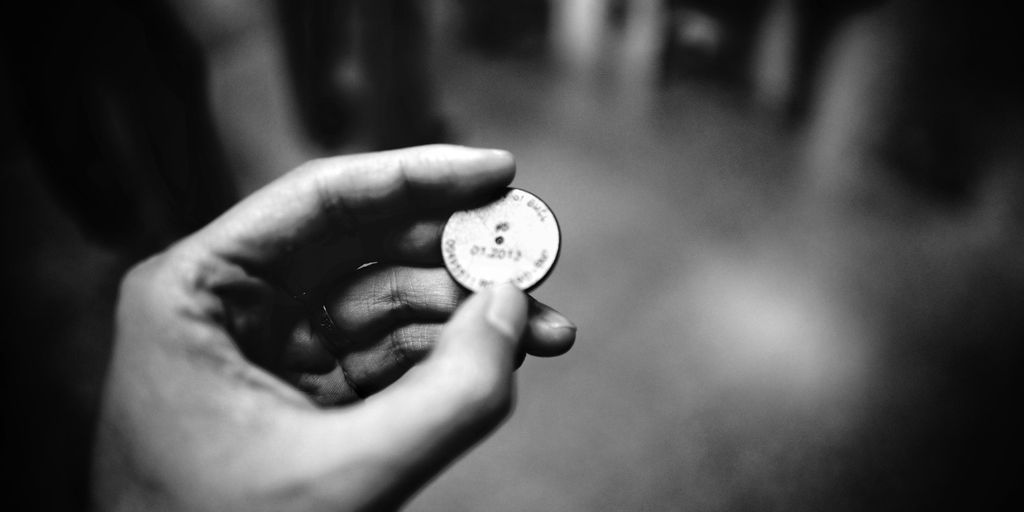grayscale photography of person holding coin