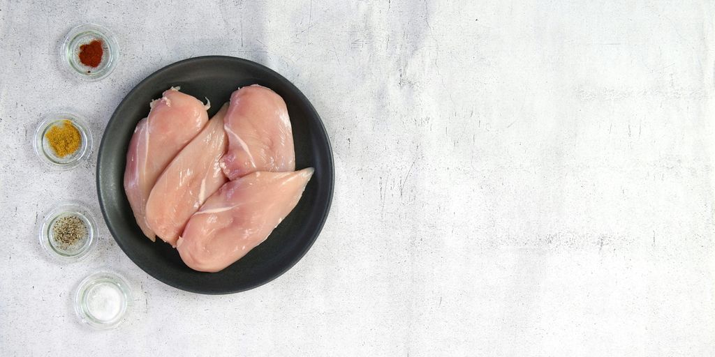 two raw chicken breasts in a black bowl
