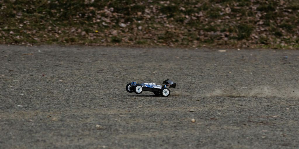 A remote-controlled car kicks up dirt.