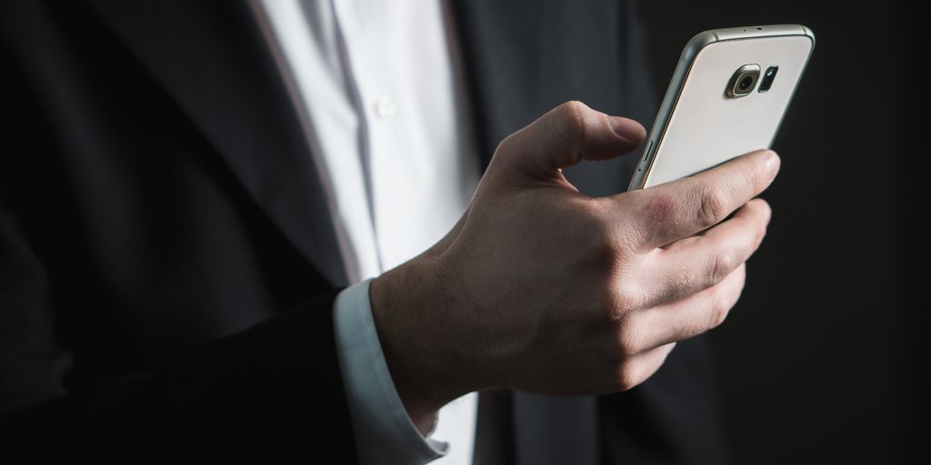 person using a smartphone to edit videos, social media icons, viral content, urban setting