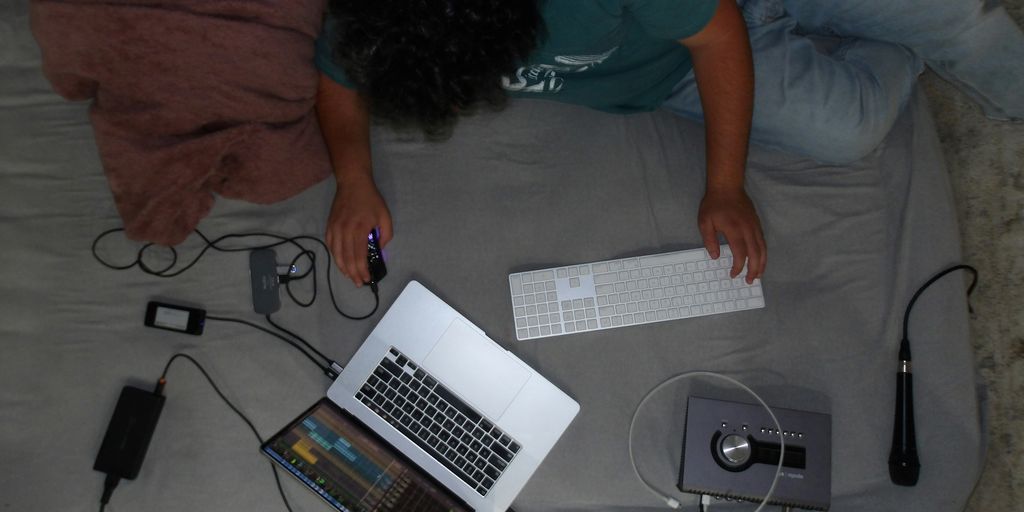 A person laying on a bed with a laptop