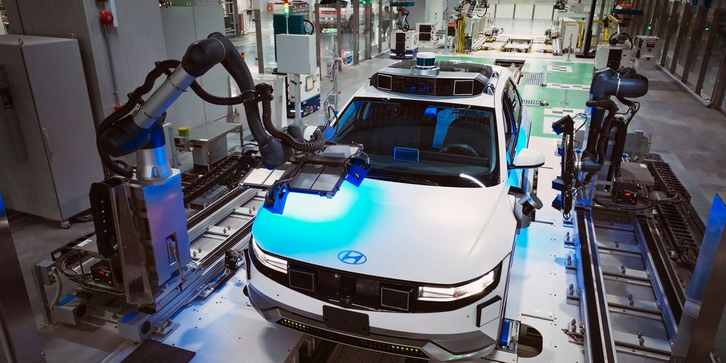 a white car is on a assembly line