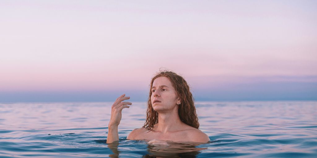 A woman floating in the water with her hand up