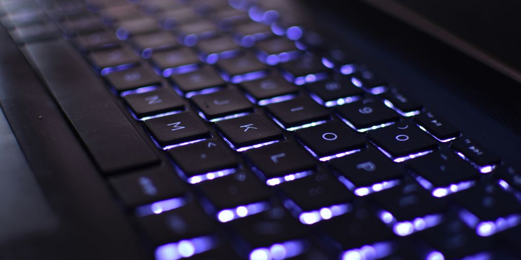 a close up of a computer keyboard with blue lights