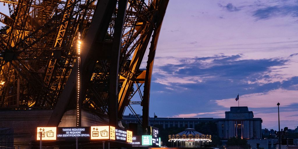 the eiffel tower is lit up at night