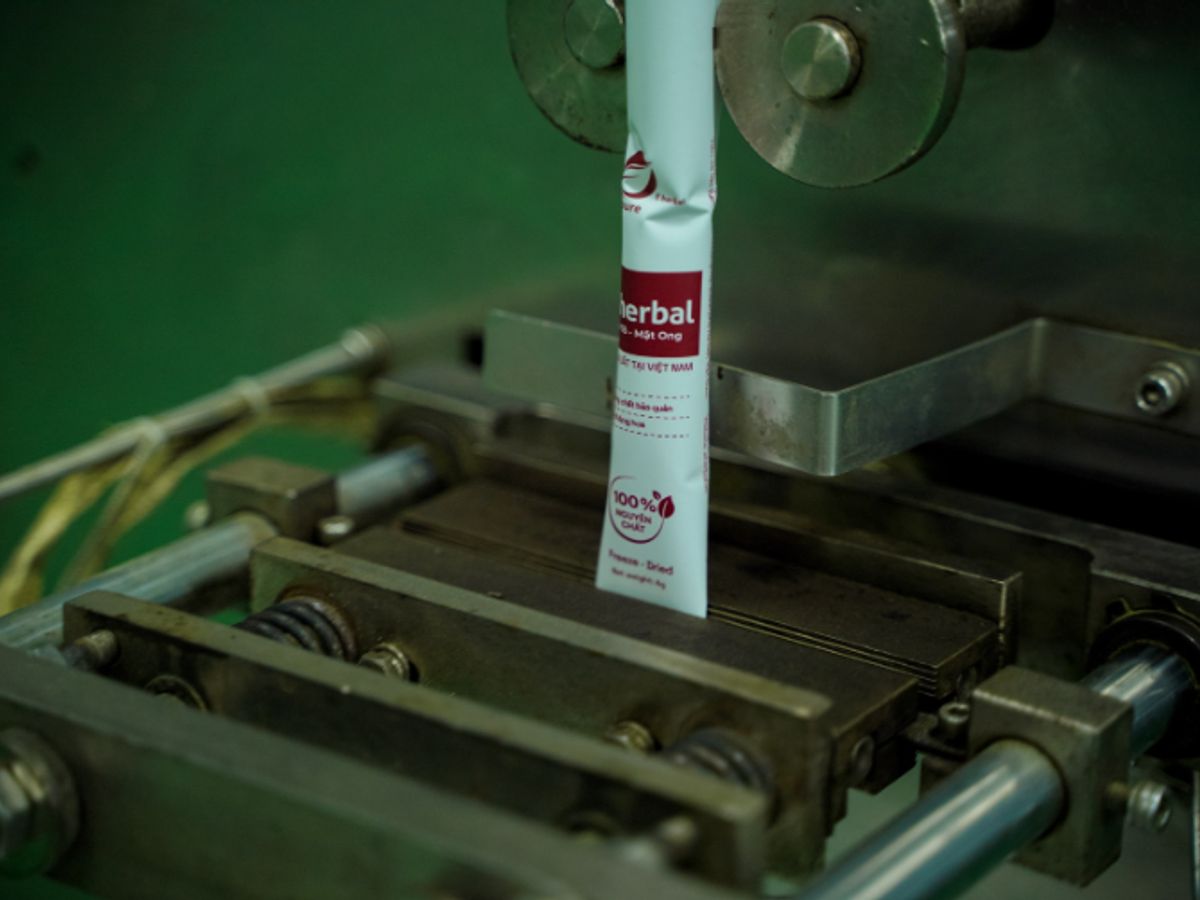 A tube is being processed in a manufacturing machine.
