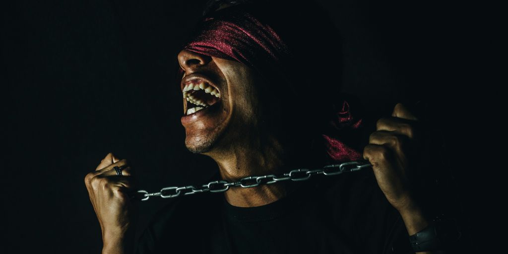 man with chain and blind fold