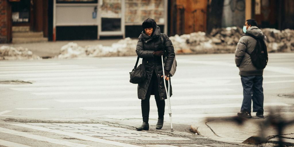 woman in black jacket and black pants walking on snow covered ground during daytime