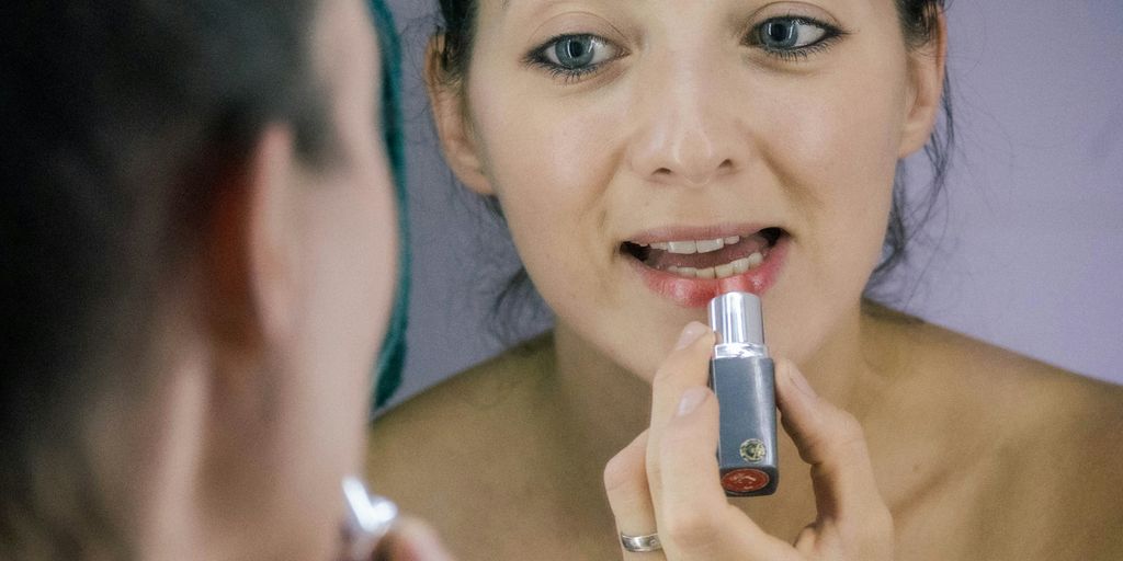 a woman brushing her teeth in front of a mirror