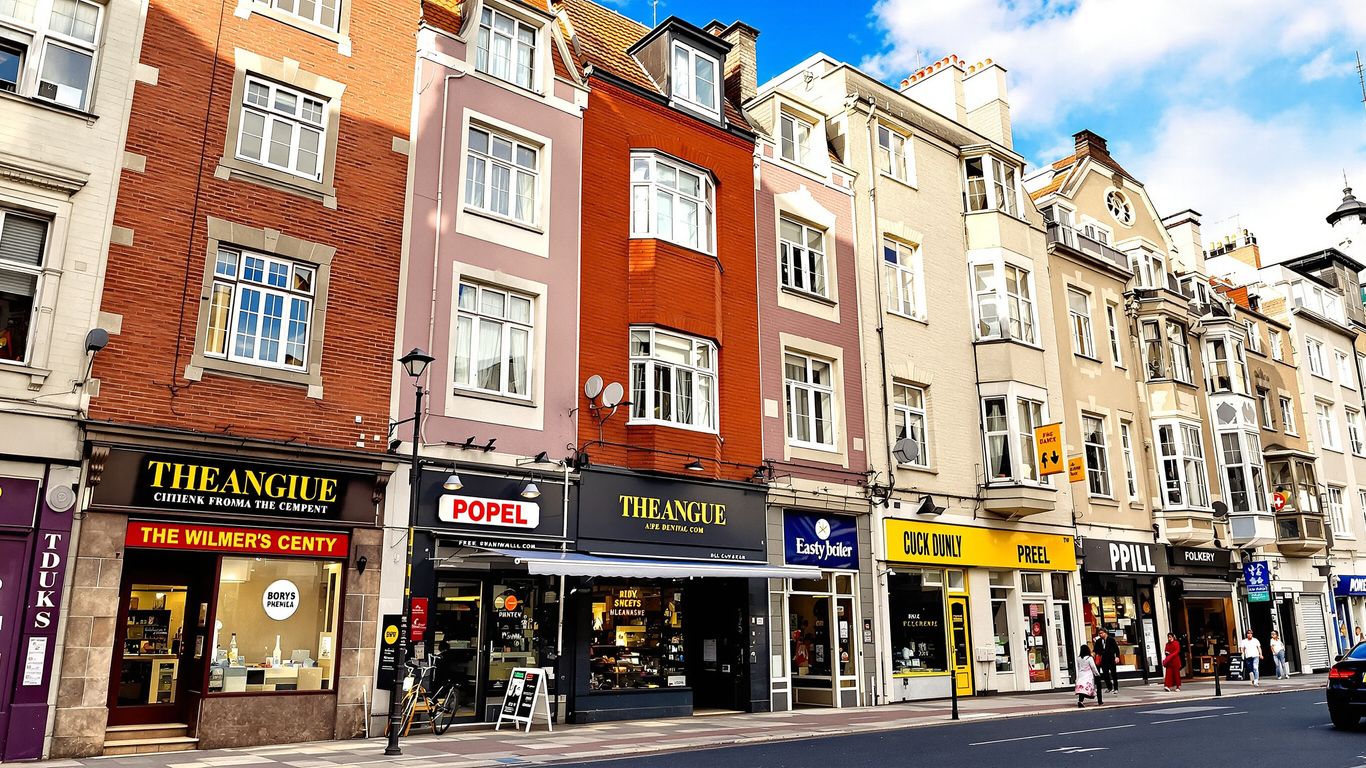 Street view of mixed-use buildings with shops and apartments.
