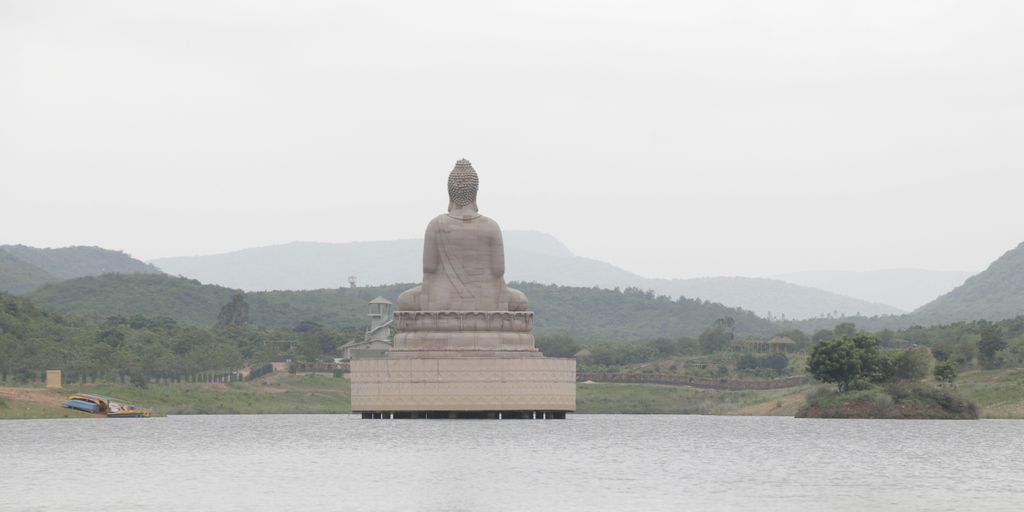 brown concrete statue near body of water during daytime