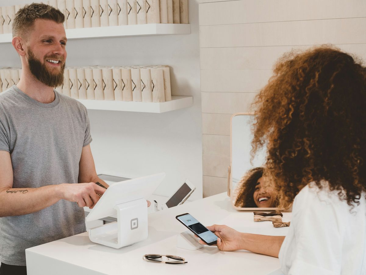man in grey crew-neck t-shirt smiling to woman on counter