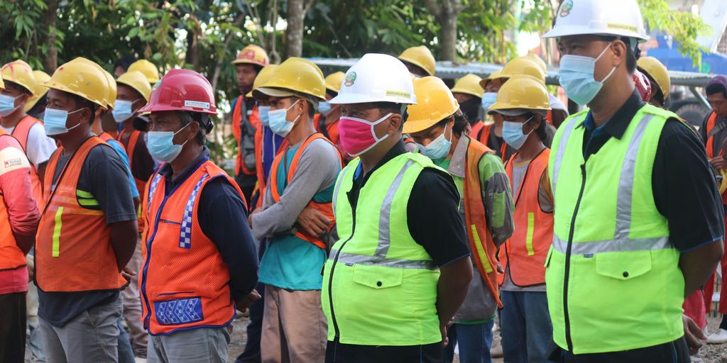 group of people wearing orange hard hat and backpacks