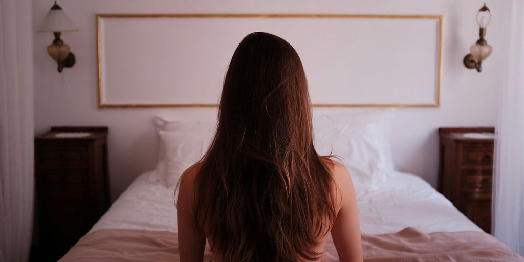 topless woman sitting on bed