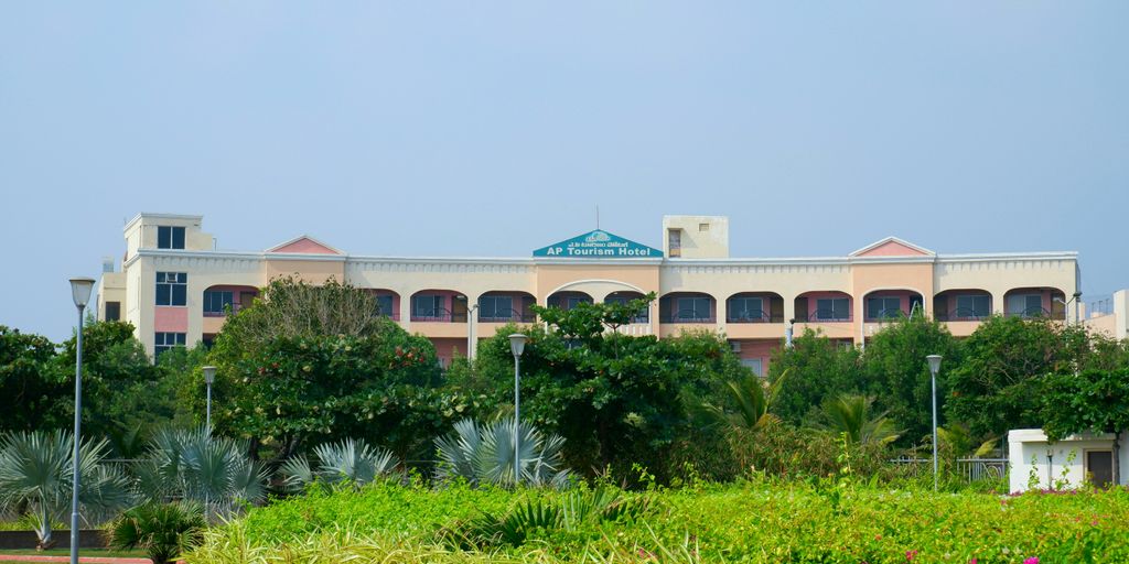 A large building sits amidst greenery.