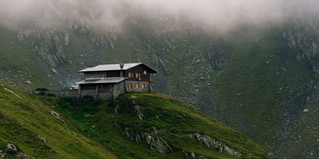 a house sitting on top of a lush green hillside