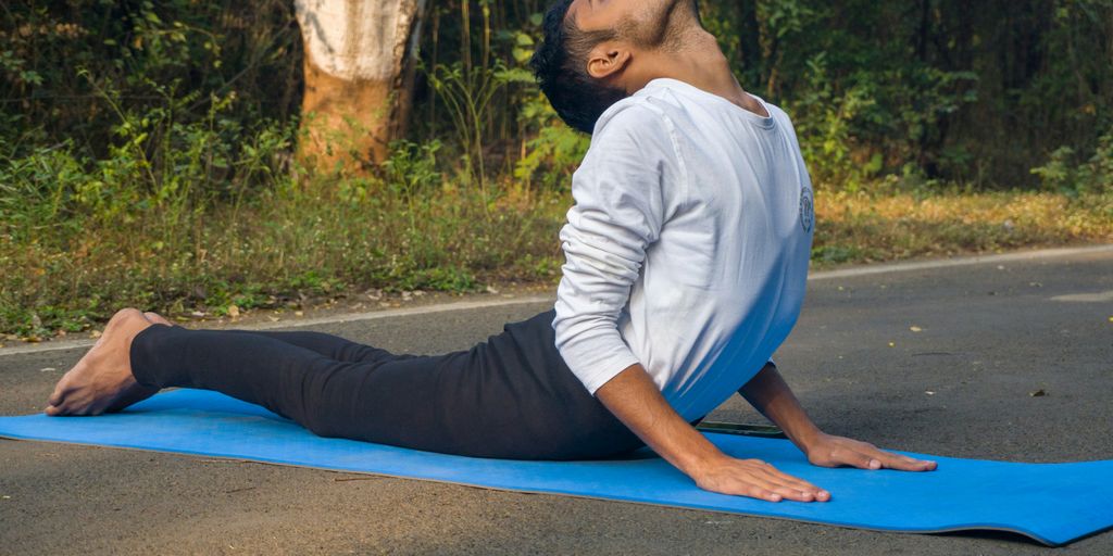 A man sitting on a blue mat in the middle of the road